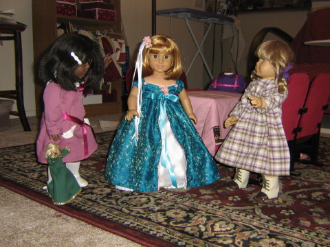 Nellie wears the dress while the others look on.