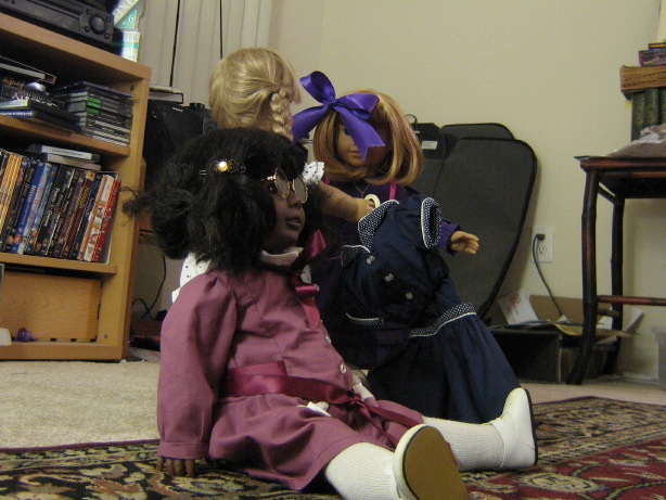 May sits down in front of Kirsten and Nellie. (Nellie is holding her swimsuit.)